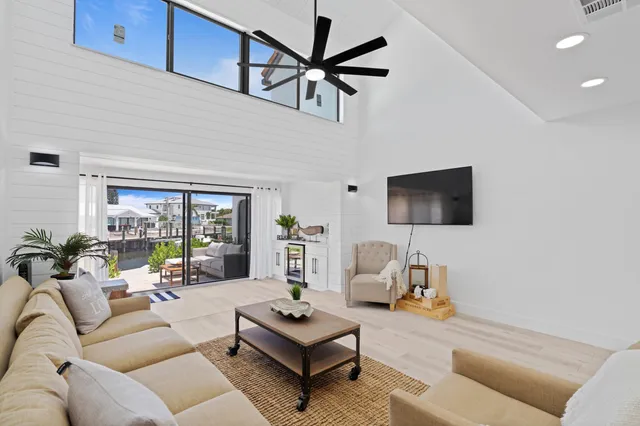 a living room with furniture a flat screen tv and a wall painting