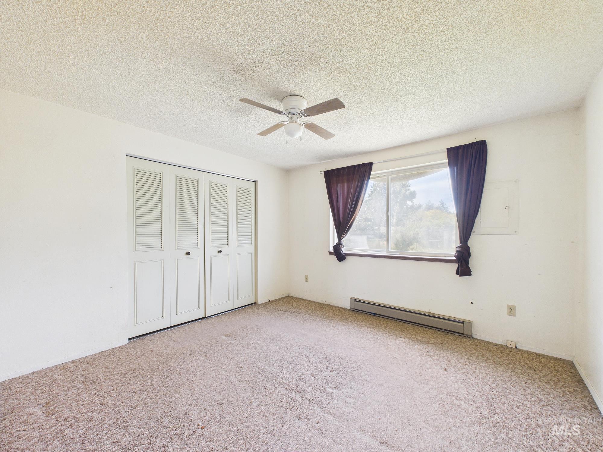 1527 North Plaza Road Emmett, ID 83617 - Photo 19 of 33 Carpeted room featuring a ceiling fan, a window, and bifold closet doors