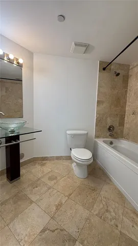 a bathroom with a granite countertop bathtub toilet and a sink