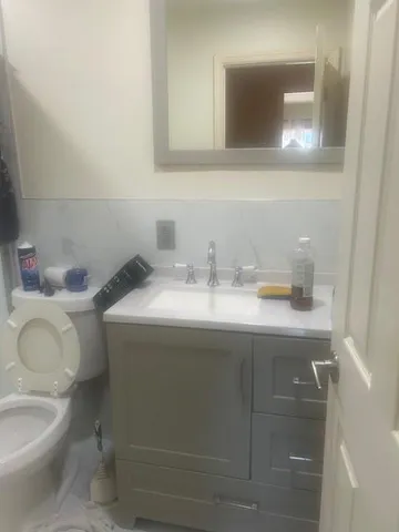 a bathroom with a sink toilet and mirror