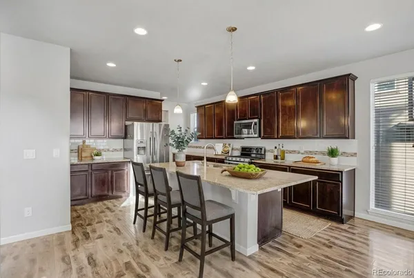 a kitchen with kitchen island granite countertop wooden cabinets and stainless steel appliances