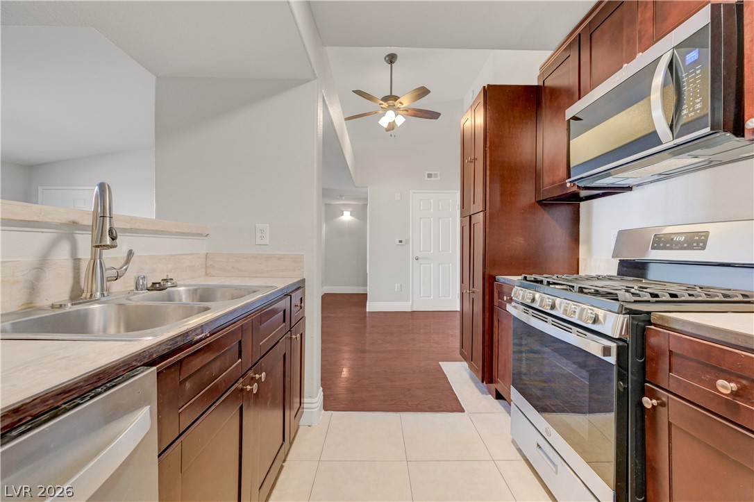 7885 West Flamingo Road, Unit 1050 Las Vegas, NV 89147 - Photo 18 of 62 A well-appointed kitchen showcasing dark wood cabinetry and modern stainless steel appliances.