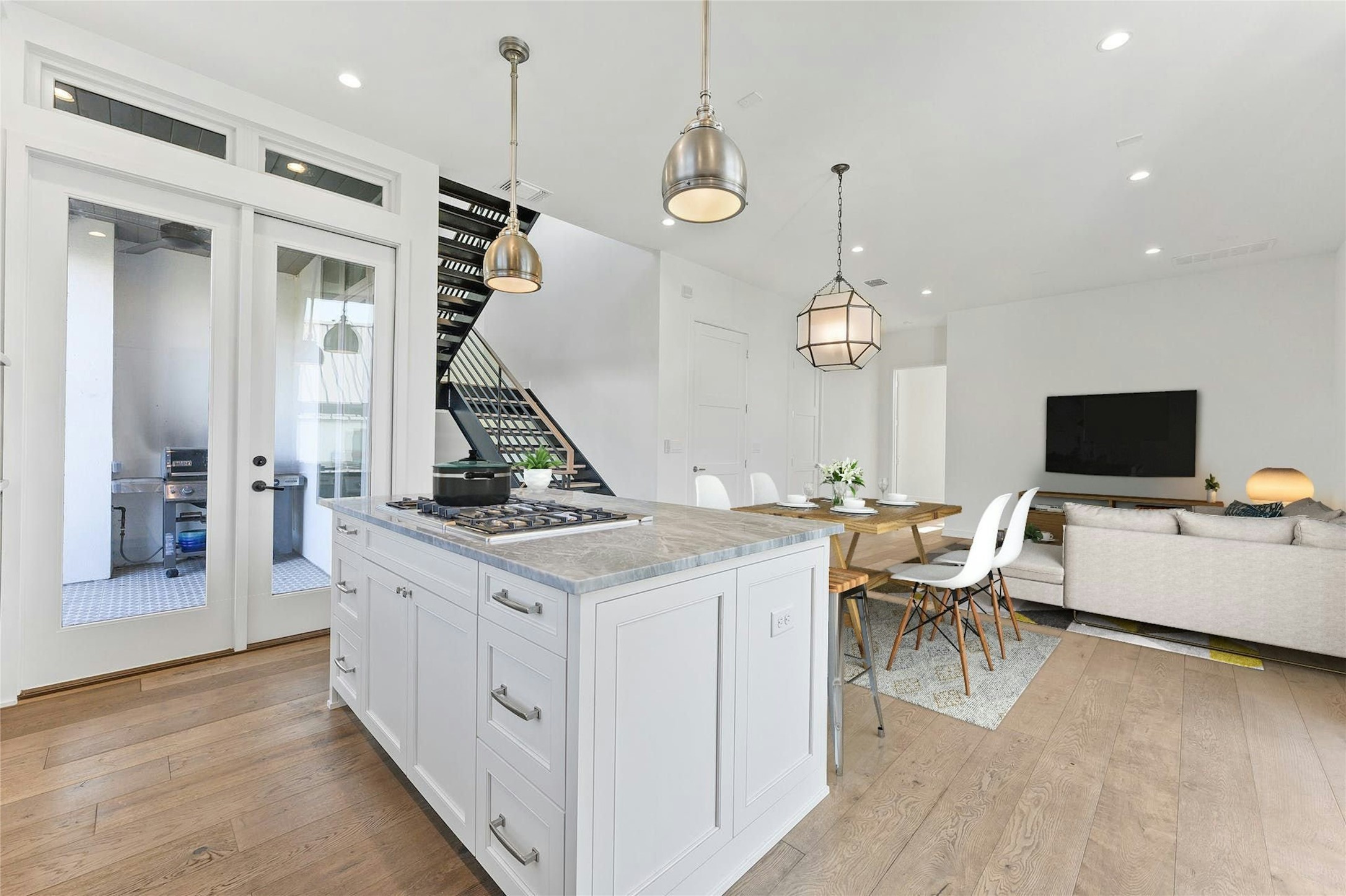 2518 Sutherland Street Austin, TX 78746 - Photo 10 of 30 An open concept design seamlessly connects the kitchen and living areas, offering both functionality and flow.