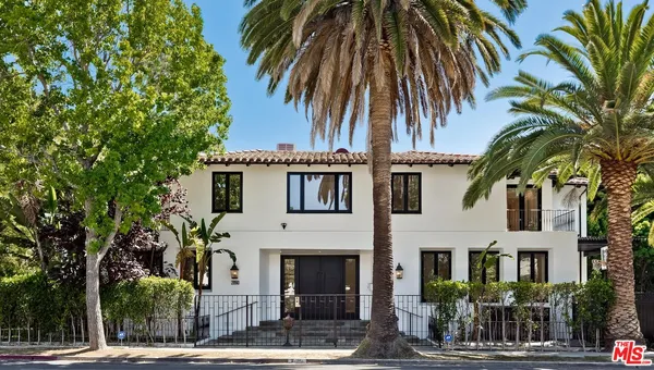 a front view of a house with a tree