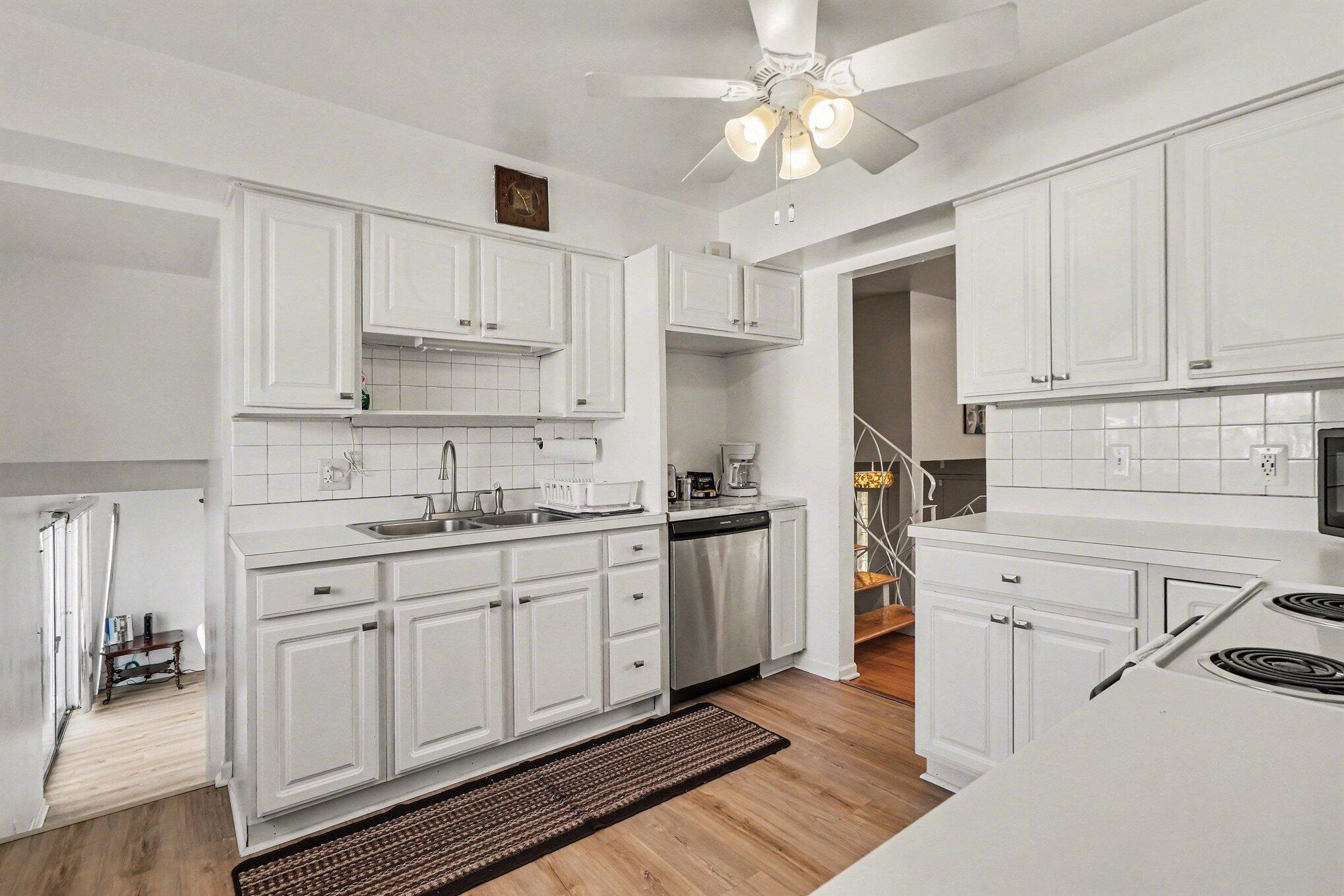 551 Union Place Gary, IN 46403 - Photo 15 of 28 a kitchen with a sink dishwasher and white cabinets with wooden floor