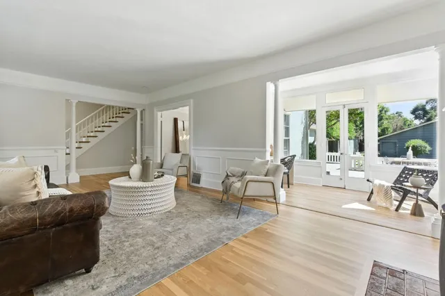 a dining room with wooden floor a chandelier a wooden table and chairs