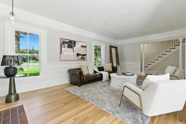 a dining room with wooden floor a chandelier a wooden table and chairs