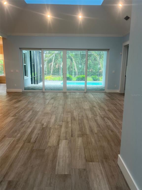 65 Sandy Beach Way Palm Coast, FL 32137 - Photo 82 of 85 a view of an empty room with wooden floor and a window