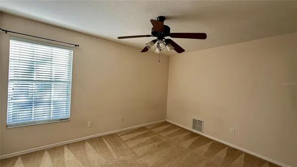 a view of a room with a window and a ceiling fan