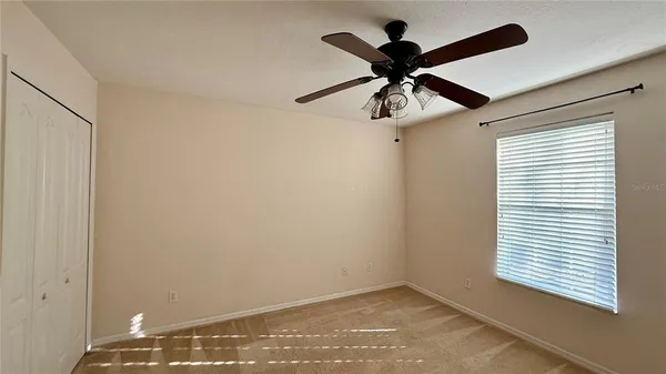 a view of a room with a ceiling fan and a window