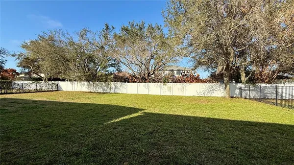 a view of yard with swimming pool and trees