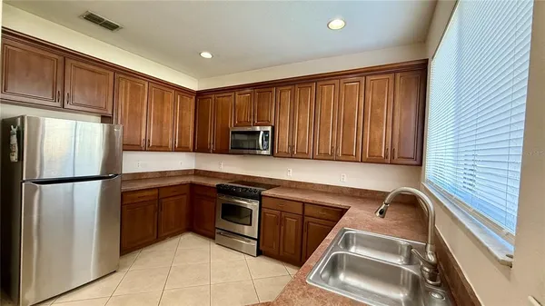 a kitchen with a refrigerator sink and cabinets