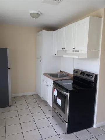 a kitchen with a stove top oven and cabinets