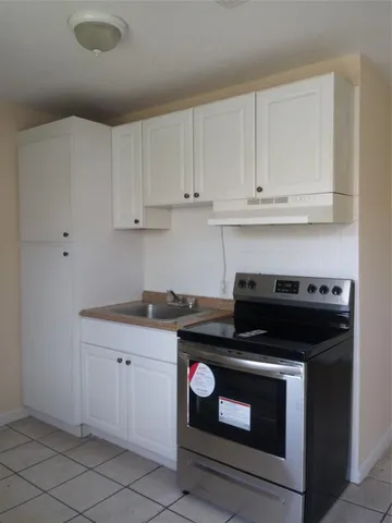 a kitchen with granite countertop white cabinets and stainless steel appliances