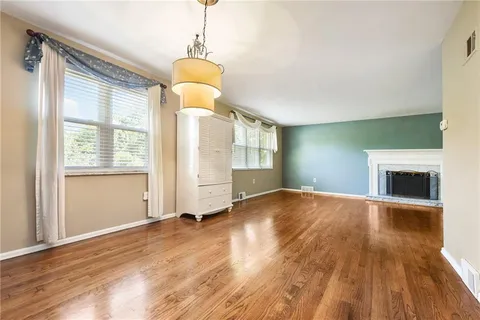 a view of empty room with wooden floor and fireplace