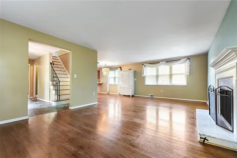 a view of a livingroom with wooden floor and a window