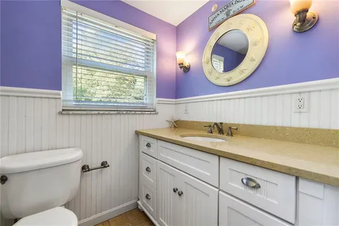 a bathroom with a granite countertop toilet sink and mirror