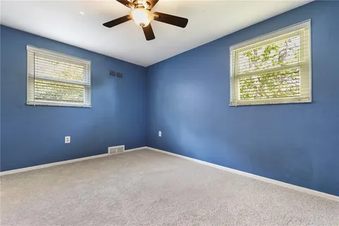 an empty room with a window and a ceiling fan