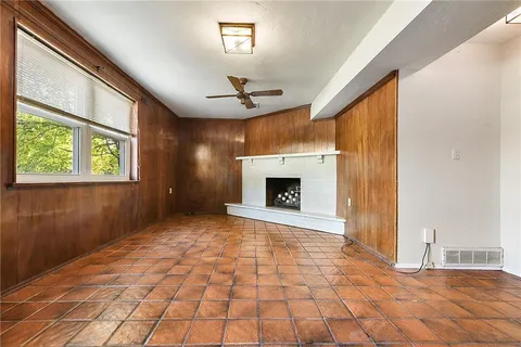 a view of an empty room with windows and a fireplace