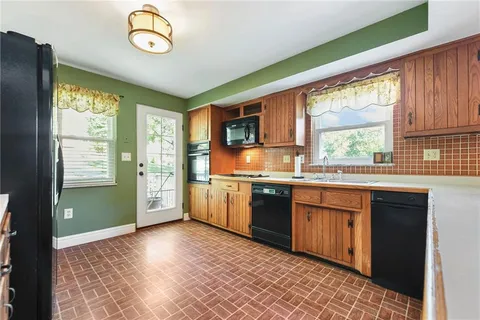 a kitchen with granite countertop a stove a sink dishwasher and a refrigerator