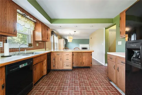 a large kitchen with stainless steel appliances granite countertop a sink and cabinets