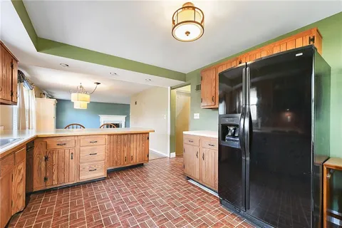 a large kitchen with stainless steel appliances kitchen island granite countertop a refrigerator a stove and a sink