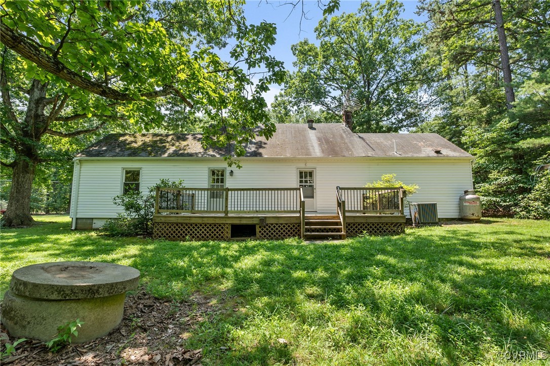 2812 Chapel Road New Canton, VA 23123 - Photo 30 of 32 a backyard of a house with table and chairs under an umbrella