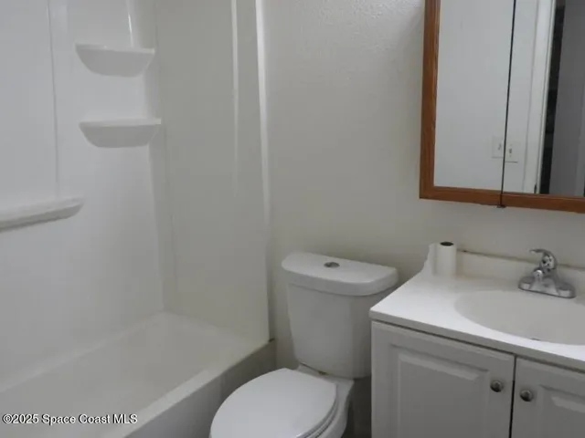 a white toilet sitting next to a bath tub