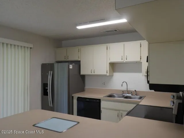 a kitchen with stainless steel appliances a sink stove refrigerator and cabinets