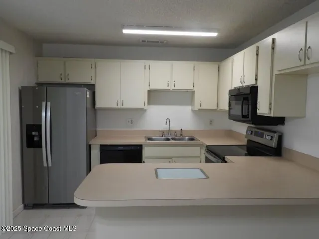 a kitchen with stainless steel appliances a refrigerator a stove a microwave and cabinets