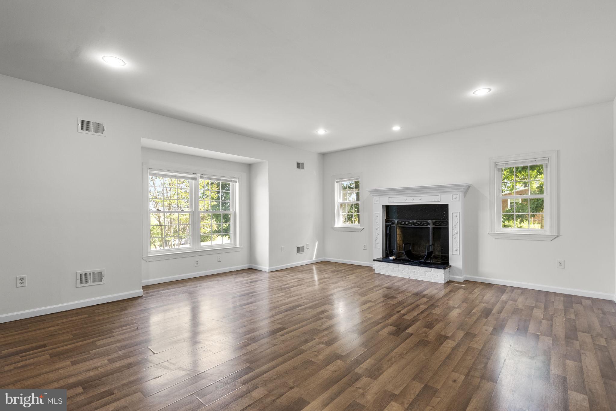 24000 Clarksburg Road Clarksburg, MD 20871 - Photo 6 of 60 an empty room with wooden floor fireplace and windows