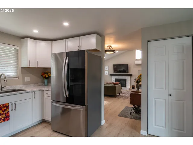 a kitchen with stainless steel appliances granite countertop a sink a refrigerator and a stove