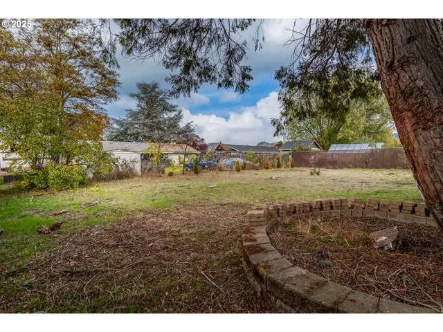 a view of a yard with a house and a large tree