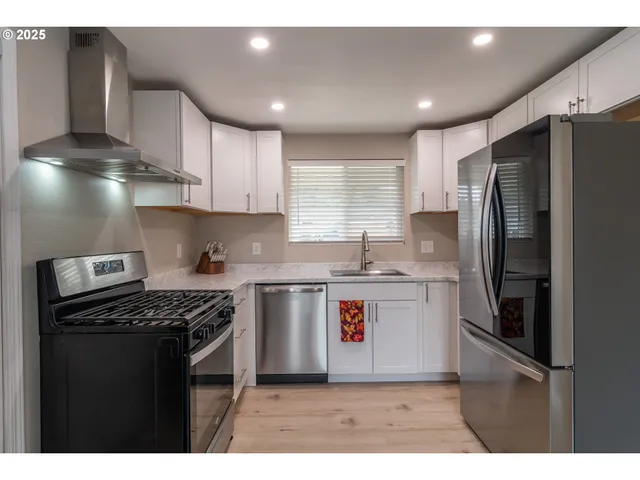 a kitchen with kitchen island stainless steel appliances a sink stove and refrigerator