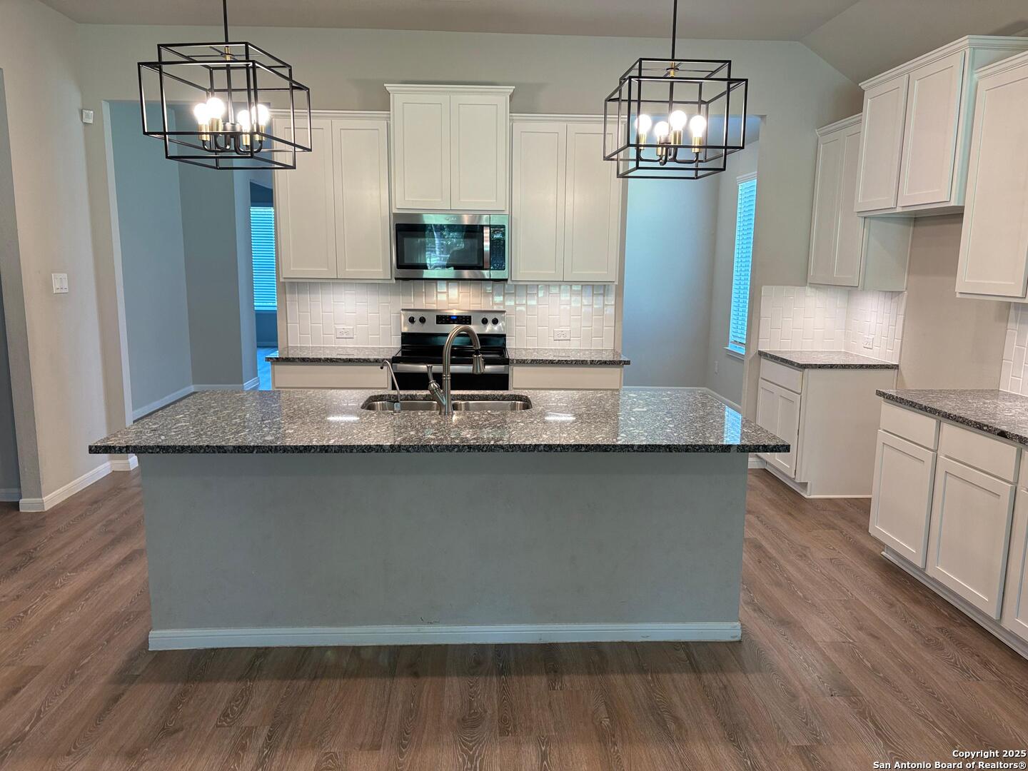 6358 Rolling Hills Road Conroe, TX 77303 - Photo 7 of 23 a kitchen with stainless steel appliances granite countertop a refrigerator a stove and a wooden floors