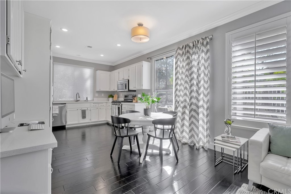 350 Exeter Way Corona, CA 92882 - Photo 20 of 56 a kitchen with stainless steel appliances kitchen island granite countertop a table chairs sink and cabinets