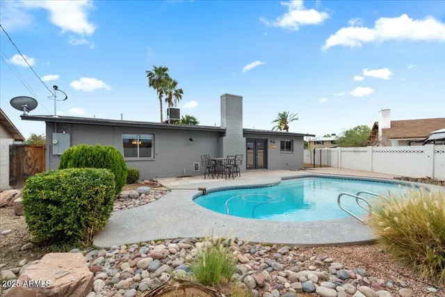 a view of a house with swimming pool and sitting area