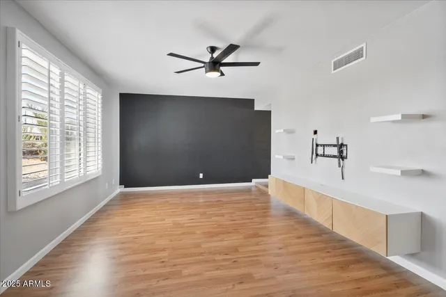 a view of a livingroom with a ceiling fan and window