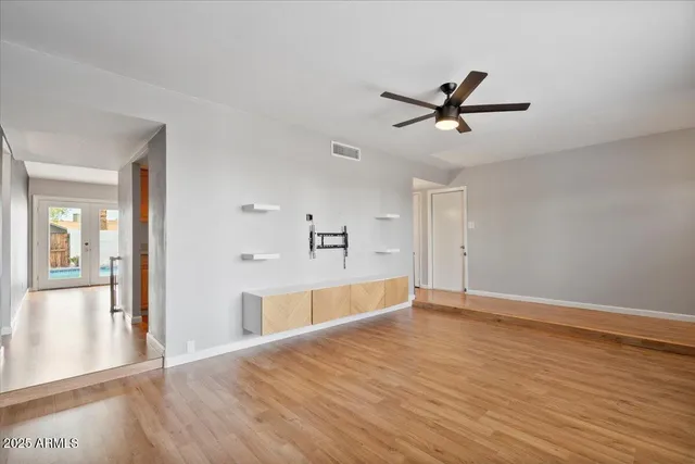 a view of a livingroom with wooden floor and a ceiling fan