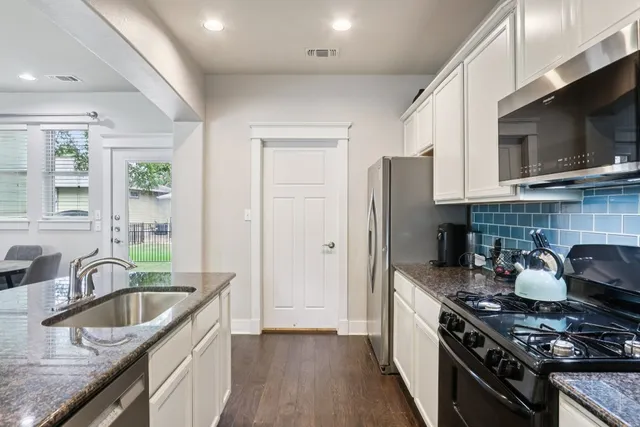 a kitchen with stainless steel appliances granite countertop a sink stove and refrigerator
