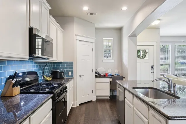 a kitchen with granite countertop a sink and living room