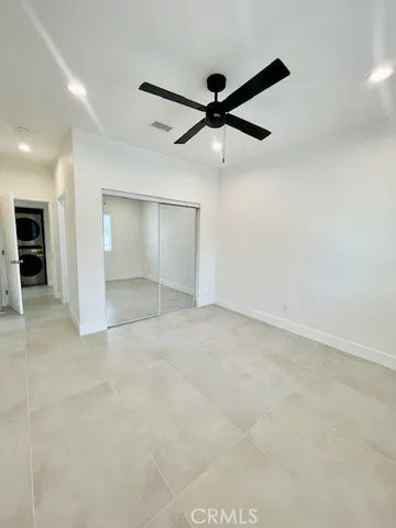 an empty room with a ceiling fan and carpet