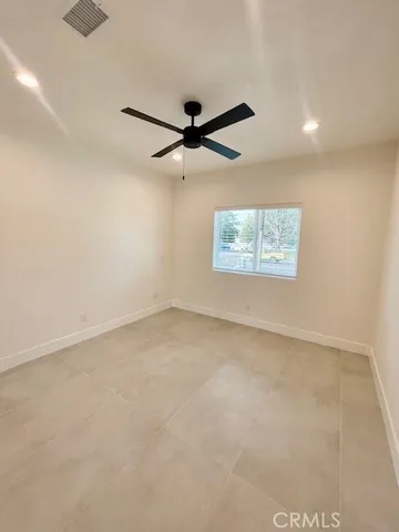 an empty room with windows and fan