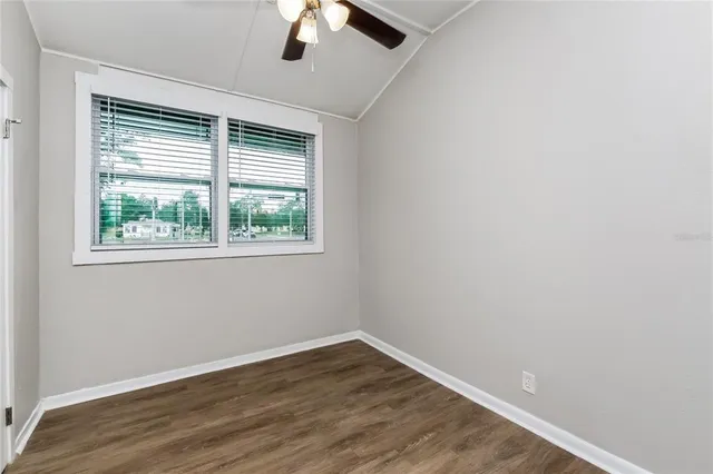 an empty room with a window and a ceiling fan