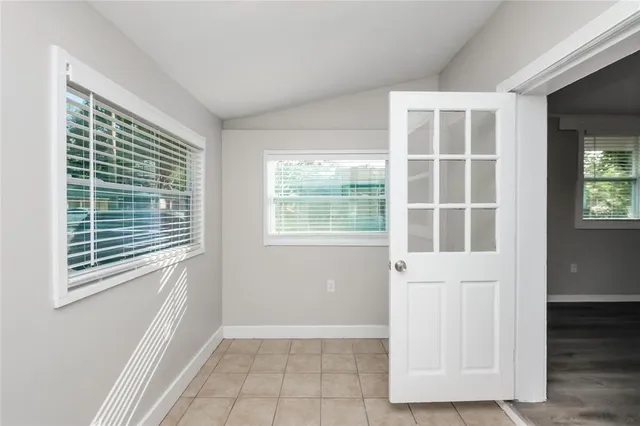 a view of an empty room with wooden floor and windows