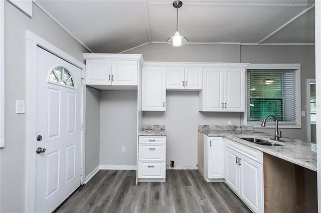 a kitchen with cabinets wooden floor and a sink