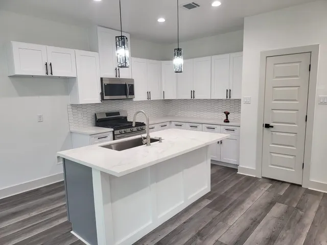 a kitchen with a stove a sink and a refrigerator