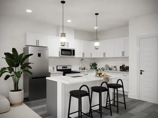 a kitchen with stainless steel appliances granite countertop a dining table chairs stove refrigerator and cabinets