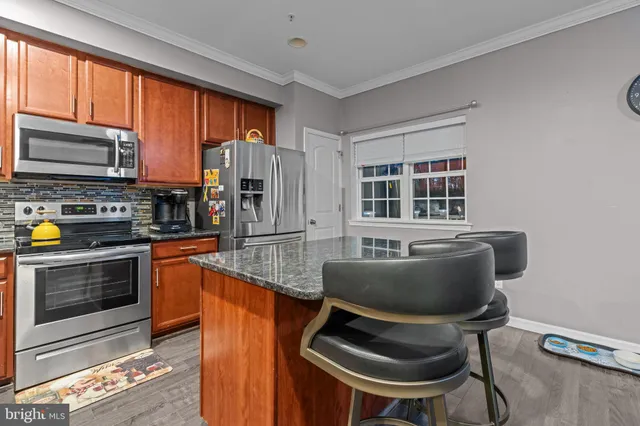 a kitchen with furniture a window and stainless steel appliances