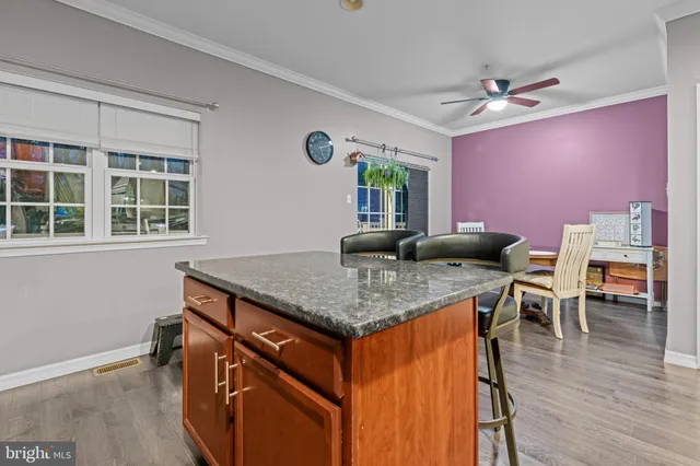 a kitchen with stainless steel appliances granite countertop a stove a kitchen island a dining table and chairs